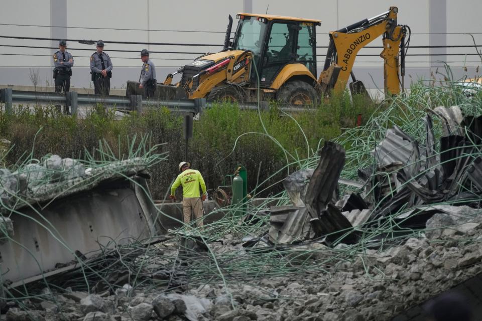 Emergency personnel are pictured working clearing the aftermath of an elevated section of Interstate 95 that collapsed in Philadelphia on Sunday.