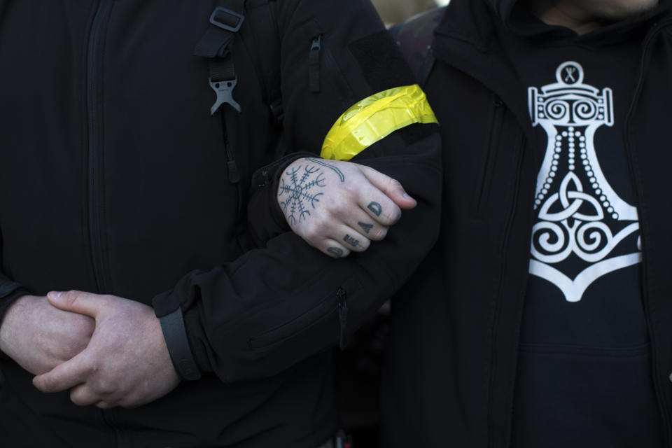 Members of right-wing National Corps march toward an election campaign rally of Petro Poroshenko, President of Ukraine and candidate for 2019 elections, in Lviv, Ukraine, Thursday, March 28, 2019. Presidential elections will be held in Ukraine on 31 March 2019. (AP Photo/Emilio Morenatti)