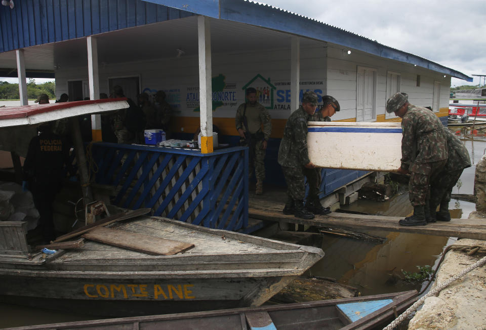 Army soldiers carry a container with seized fish illegally caught in Atalaia do Norte, Amazonas state, Brazil, Saturday, June 11, 2022. According to the police, a wildcat fisherman is the main suspect of the disappearance of British journalist Dom Phillips and Indigenous affairs expert Bruno Pereira, and authorities say illegal fishing near the Javari Valley Indigenous Territory, where Phillips and Pereira went missing last Sunday has raised the tension with local Indigenous groups in the isolated area near the country's border with Peru and Colombia. (AP Photo/Edmar Barros)