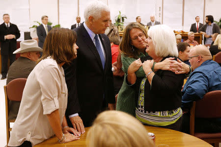 U.S. Vice President Mike Pence and his wife Karen (L) along with Sherri Pomeroy (2nd R) console a woman at Floresville high school during a visit with family and victims of the shooting at First Baptist Church in Sutherland Springs, before a vigil in Floresville, Texas, U.S., November 8, 2017. Pomeroy, wife of Pastor Frank Pomeroy, lost her daughter in the shooting. REUTERS/Jonathan Bachman