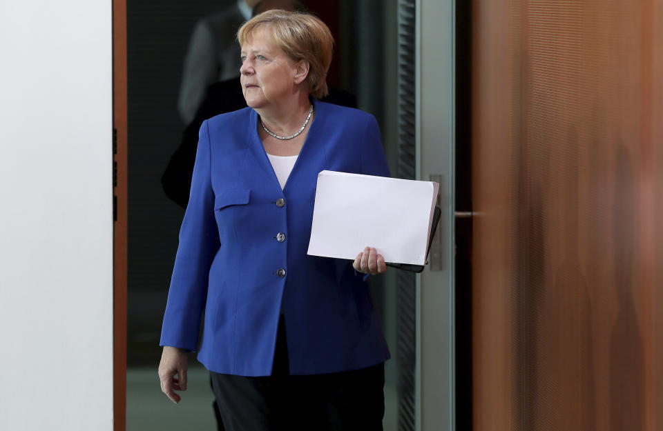 German Chancellor Angela Merkel arrives for the weekly cabinet meeting at the Chancellery in Berlin, Germany, Wednesday, Aug. 21, 2019. The German government sold 30-year bonds at a negative interest rate Wednesday Aug. 21, 2019, in a sign of the clouds over markets and future growth as well as increased expectations that more central bank stimulus is likely on the way.(AP Photo/Michael Sohn)