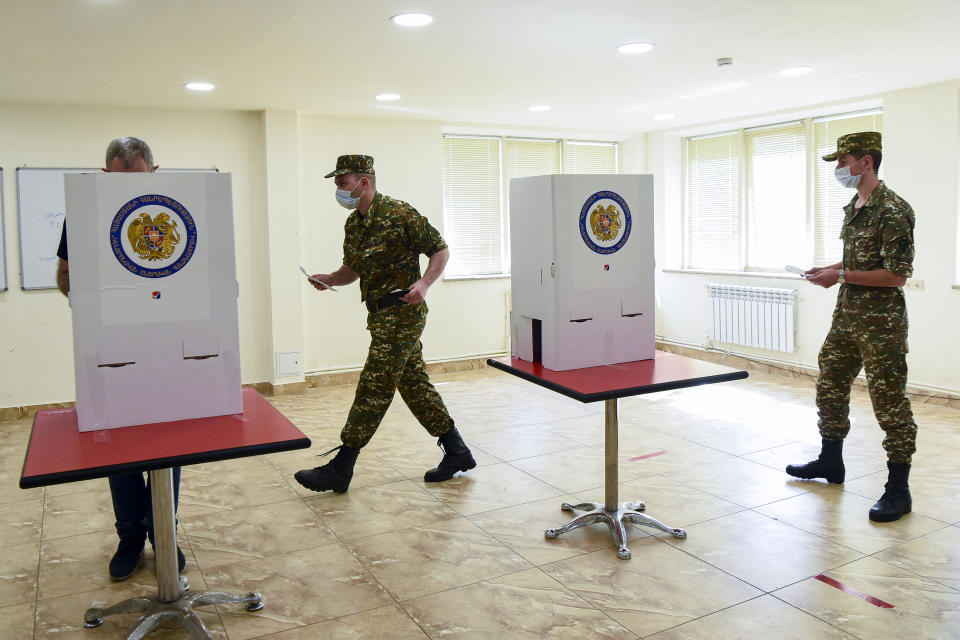 Armenian Army soldiers cast their ballots at a polling station during a parliamentary elections in Yerevan, Armenia, Sunday, June 20, 2021. Armenians are voting in a national election after months of tensions over last year's defeat in fighting against Azerbaijan over the separatist region of Nagorno-Karabakh. (Lusi Sargsyan, PHOTOLURE via AP)