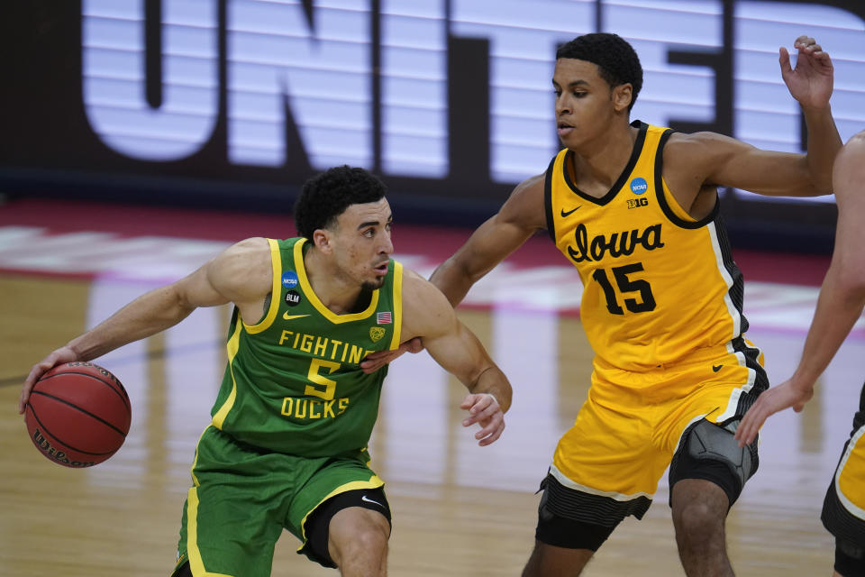 Oregon guard Chris Duarte (5) drives on Iowa forward Keegan Murray (15) during the second half of a men's college basketball game in the second round of the NCAA tournament at Bankers Life Fieldhouse in Indianapolis, Monday, March 22, 2021. (AP Photo/Paul Sancya)