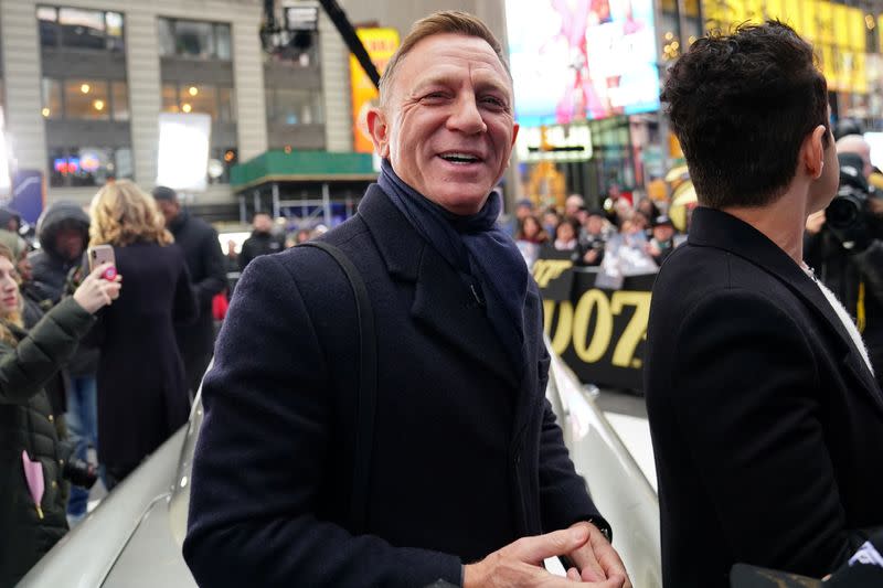 Actor Daniel Craig reacts next to actor Rami Malek during a promotional appearance on TV in Times Square for the new James Bond movie "No Time to Die" in the Manhattan borough of New York City