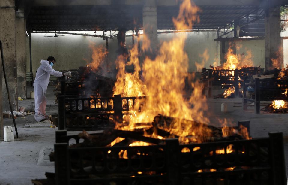 Flames rise from cremation pyres of 13 COVID-19 patients who died in a fire that broke out in Vijay Vallabh COVID-19 hospital, at Virar, near Mumbai, India, Friday, April 23, 2021. Delhi has been cremating so many bodies of coronavirus victims that authorities are getting requests to start cutting down trees in city parks, as a second record surge has brought India's tattered healthcare system to its knees. (AP Photo/Rajanish Kakade)