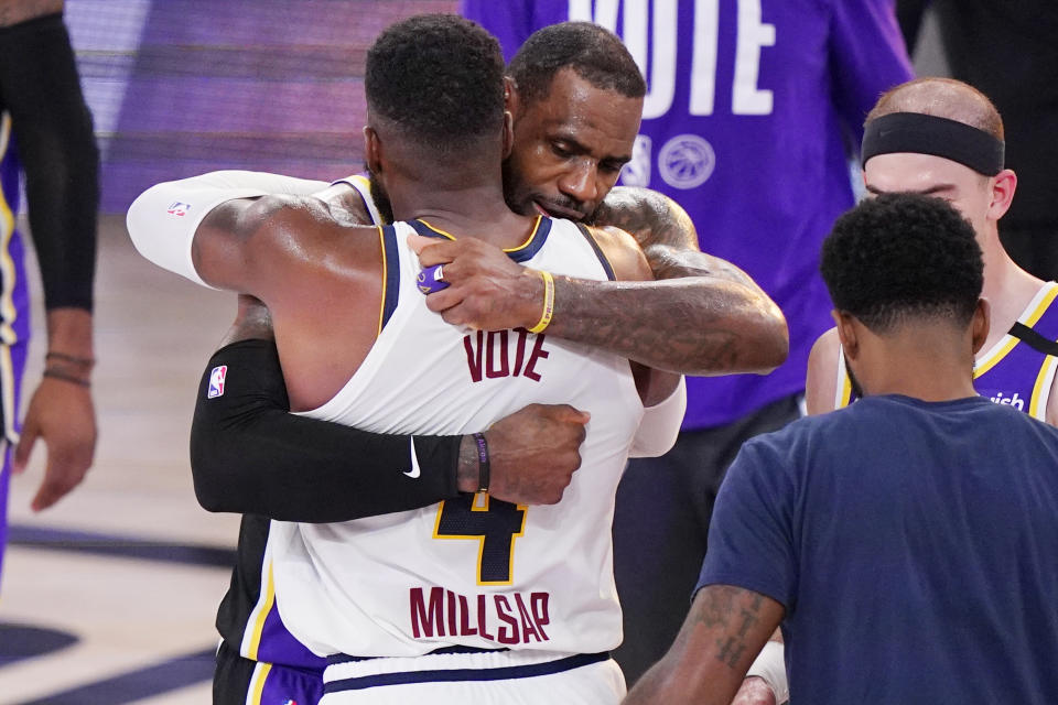 Los Angeles Lakers' LeBron James hugs Denver Nuggets' Paul Millsap (4) after the Lakers won their NBA conference final playoff basketball game Saturday, Sept. 26, 2020, in Lake Buena Vista, Fla. The Lakers won 117-107 to win the series 4-1. (AP Photo/Mark J. Terrill)