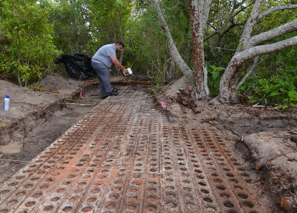 Jorge González, a University of South Florida 3D applications engineer, aims a structured light scanner at the recently unearthed Marston matting entry walkway that led into the Bumper blockhouse at Cape Canaveral Space Force Station.