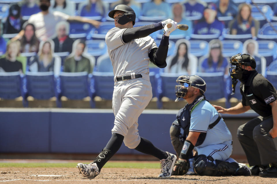 New York Yankees' Aaron Judge follows through on his second solo home run as Toronto Blue Jays catcher Alejandro Kirk and home plate umpire Tripp Gibson look on during the fourth inning of a baseball game Wednesday, April 14, 2021, in Dunedin, Fla. (AP Photo/Mike Carlson)