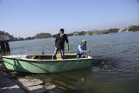 Tourists feed fish at Surinsar Lake on the outskirts of Jammu, India, Wednesday, March 3, 2021. (AP Photo/Channi Anand)