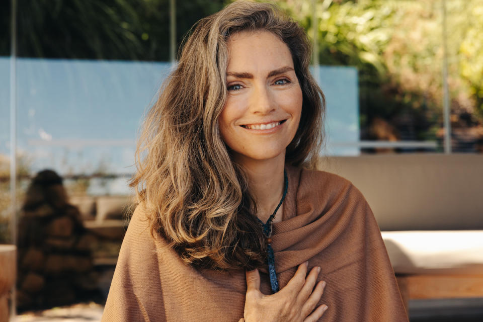 Woman holding hand to heart and smiling