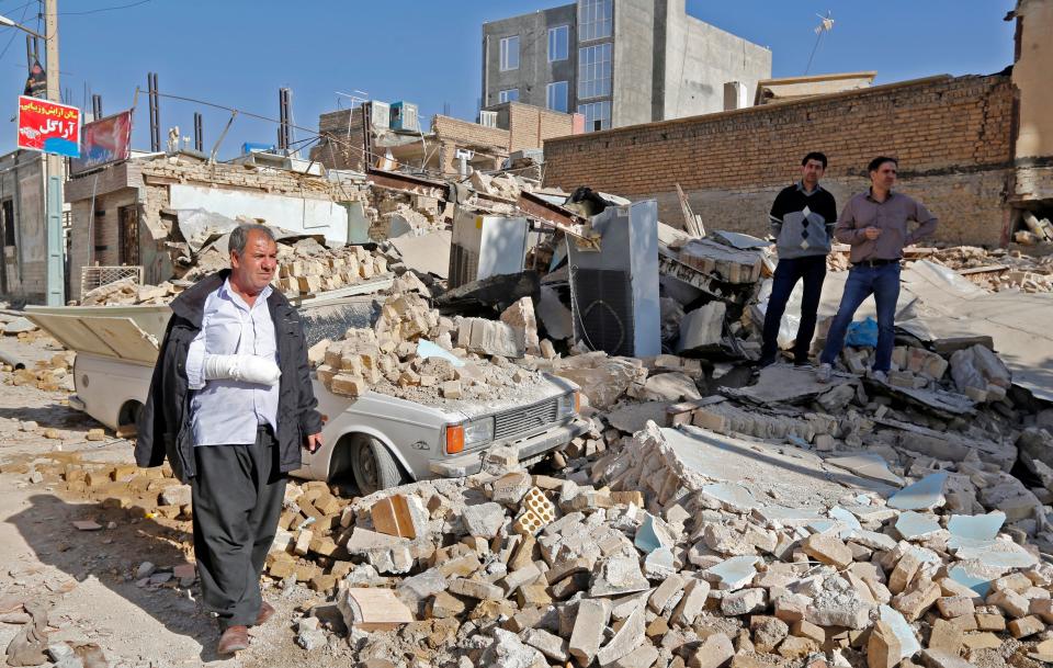 An injured Iranian walks&nbsp;through rubble in Sarpol-e Zahab, a town in&nbsp;Iran's western Kermanshah Province, on Tuesday. (Photo: ATTA KENARE via Getty Images)