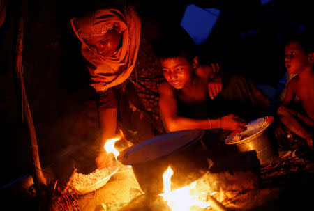 Rohingya refugees cook food while having dinner in a new makeshift camp, in Cox's Bazar, Bangladesh September 16, 2017. REUTERS/Mohammad Ponir Hossain