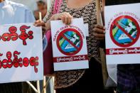 Protesters hold flyers against Myitsone hydropower dam during the last day of Chinese President Xi Jinping's visit in Yangon