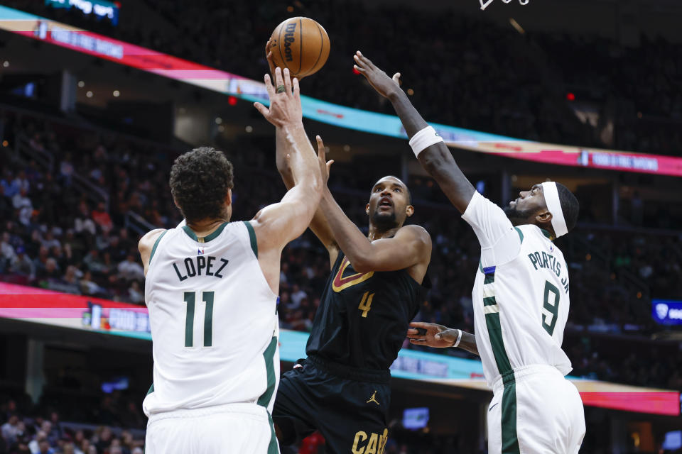 Cleveland Cavaliers forward Evan Mobley (4) shoots against Milwaukee Bucks center Brook Lopez (11) and forward Bobby Portis (9) during the second half of an NBA basketball game, Saturday, Jan. 21, 2023, in Cleveland. (AP Photo/Ron Schwane)