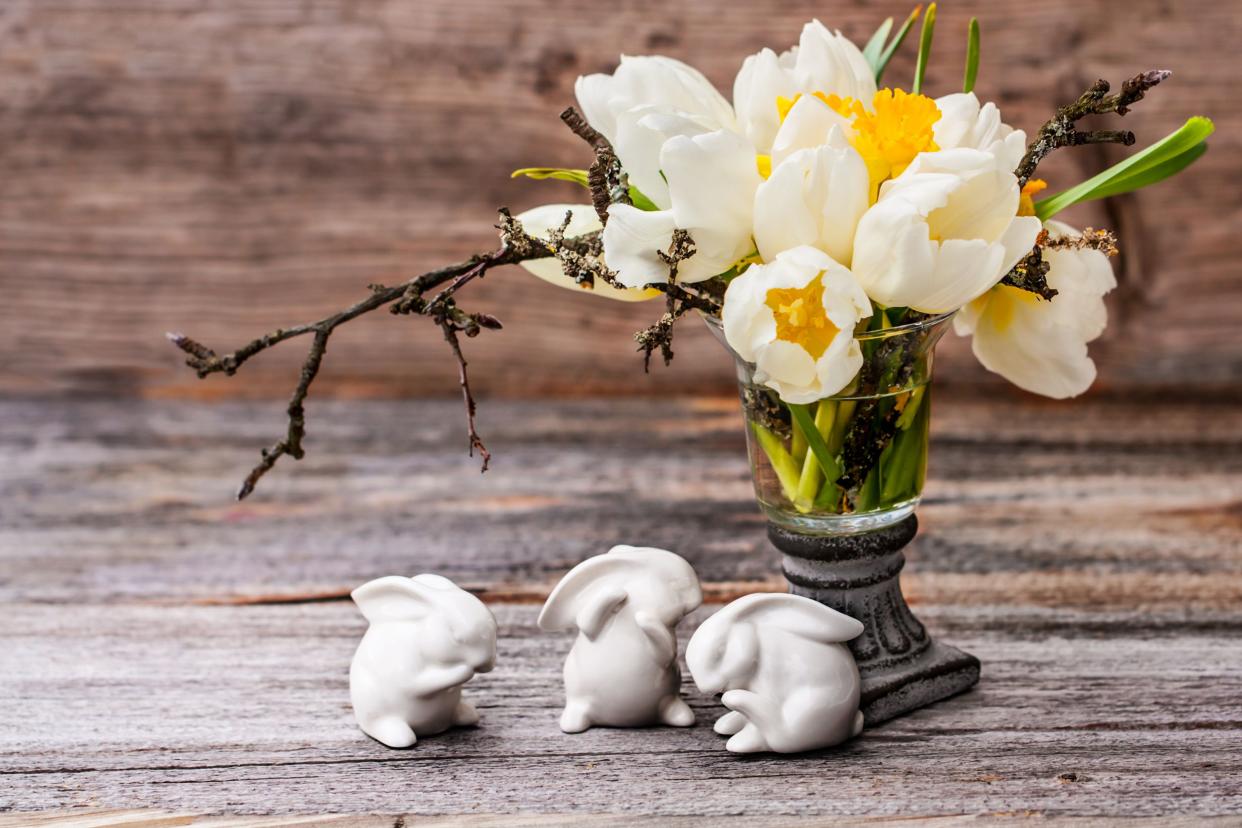 White bunny figurines next to a flower arrangement