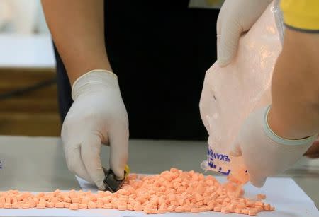 Agents from the Bureau of Customs (BOC) Anti-Illegal Drugs Task Force inspect "party drugs" intercepted from parcels containing an estimated three million pesos ($64,400) worth of ecstasy pills from Germany at the Ninoy Aquino International Airport during a news briefing at the BOC headquarters in Pasay City, metro Manila, Philippines August 24, 2016. REUTERS/Romeo Ranoco