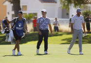Tom Kim, center, of South Korea, and Max Homa, right, walk down the fairway at the ninth hole during the first round of the Shriners Children's Open golf tournament at TPC Summerlin, Thursday, Oct. 6, 2022, in Las Vegas. (AP Photo/Ronda Churchill)