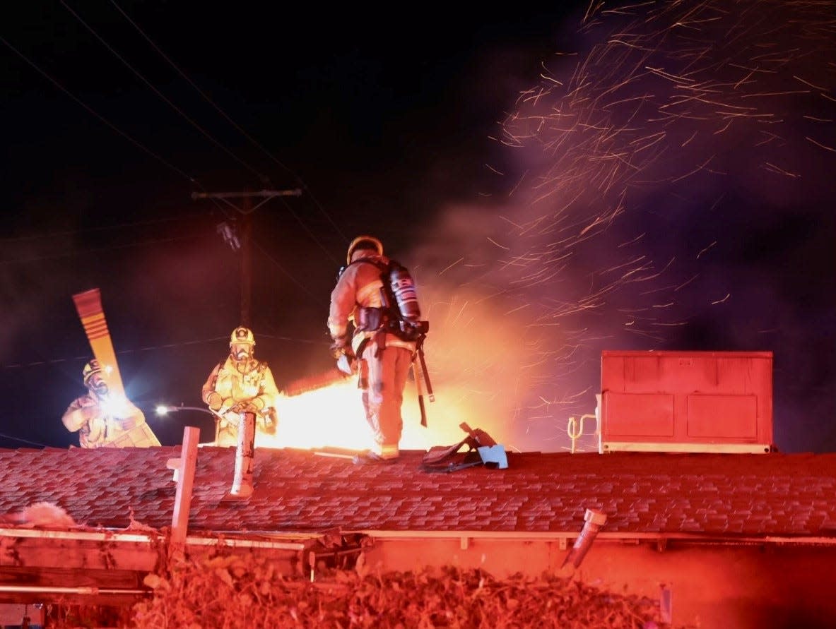 Firefighters battle a blaze Sunday night at a home at Fourth Street and California Avenue in a residential area in Simi Valley.