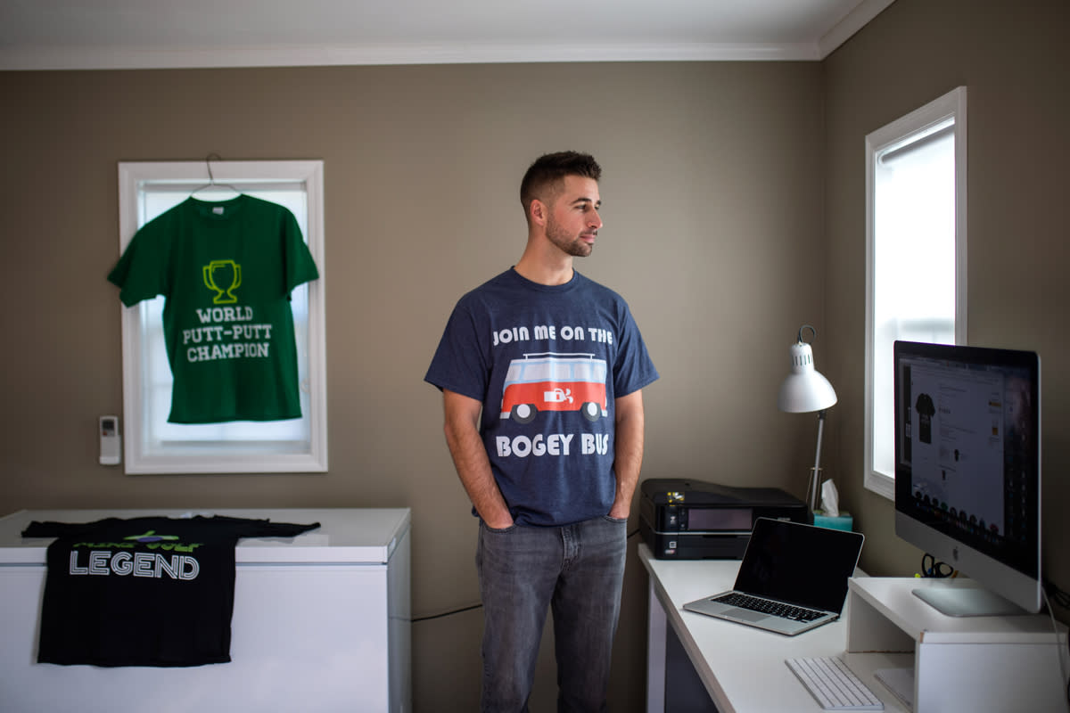 A t-shirt designer poses for a portrait while wearing one of his designs. 