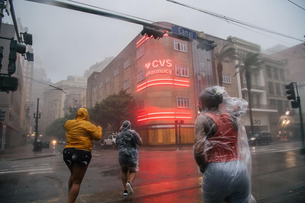 A group of people crosses an intersection during Hurricane Ida on Aug. 29, 2021, in New Orleans, La.