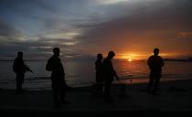 Government soldiers stand guard at a port in downtown Zamboanga September 11, 2013. Moro National Liberation Front (MNLF) rebels seeking to declare an independent state put a dozen civilians tied together by rope on display as a human shield on Wednesday as a standoff with security forces in a southern Philippine city entered its third day. (REUTERS/Erik De Castro)