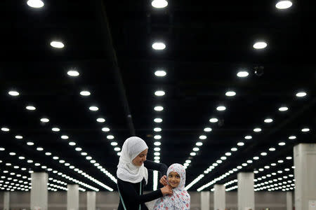 Salma Selenica, 12, adjusts the headscarf of her sister Layla, 8, ahead of the jenazah, an Islamic funeral prayer, for the late boxing champion Muhammad Ali in Louisville, Kentucky, June 9, 2016. REUTERS/Adrees Latif