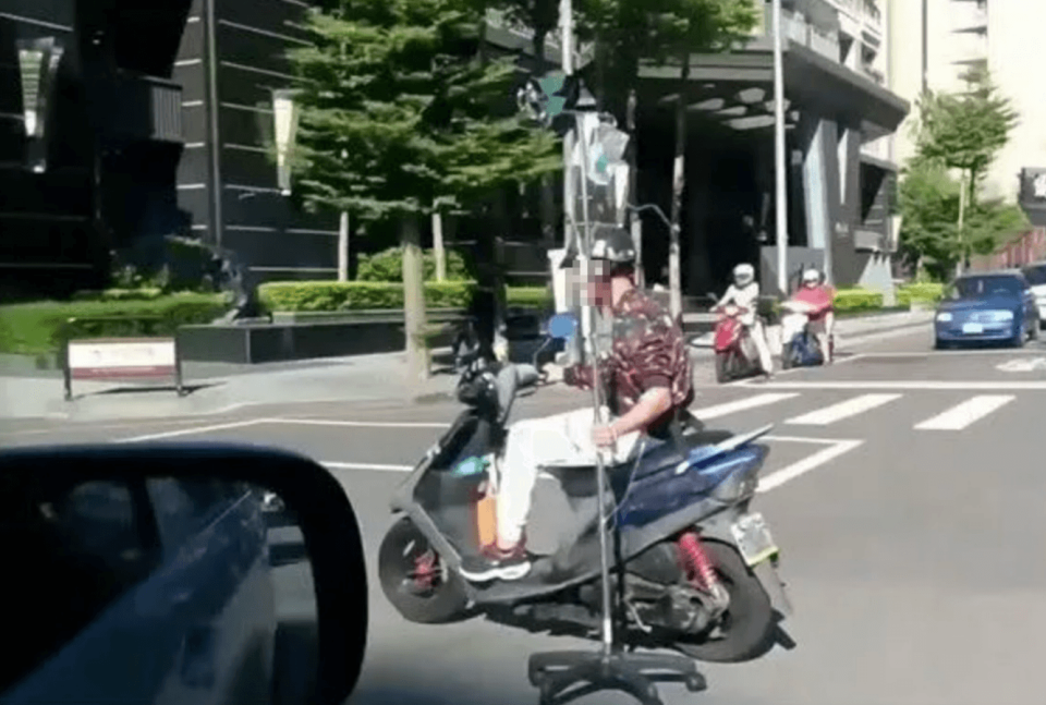 台中一名年約60歲的阿伯邊騎車邊吊點滴，讓其他民眾為他捏了把冷汗。（翻攝自爆廢公社）