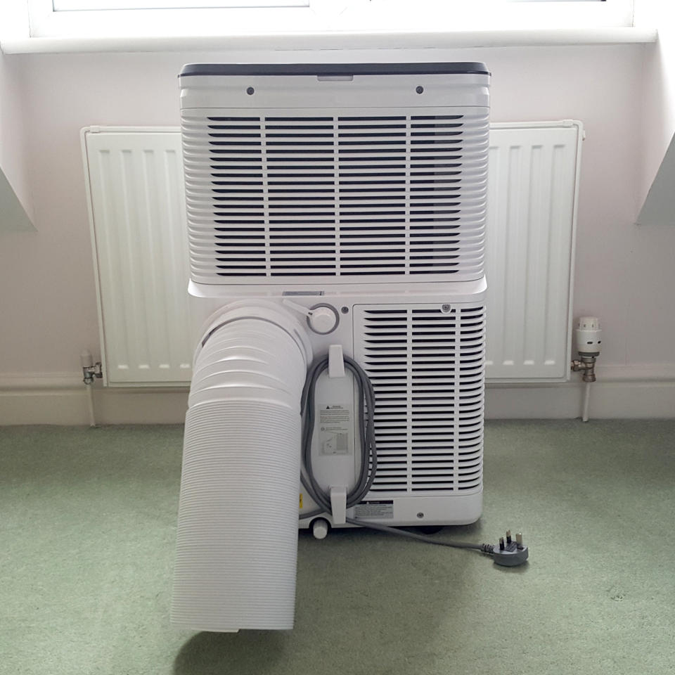 The AEG Comfort 6000 Portable Air Conditioner being tested in a room with green carpet