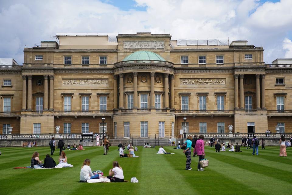 Visitors enjoy picnics on the lawn during a preview of the Garden at Buckingham Palace in 2021 (Kirsty O’Connor/PA) (PA Archive)