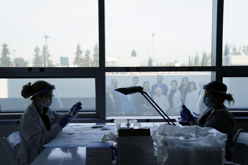 Christie Aiello, left and Denise Gomez prepare the Pfizer-BioNTech COVID-19 vaccine for medical workers at St. Joseph Hospital in Orange, Calif. Thursday, Jan. 7, 2021. (AP Photo/Jae C. Hong)