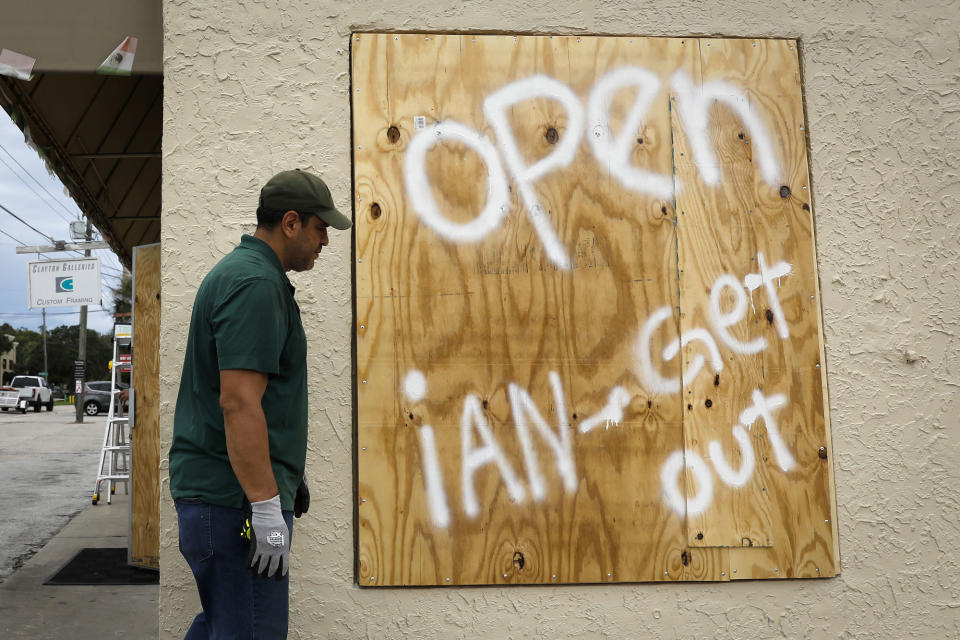 <p>A storefront sign in Tampa reads "Open, Ian Get Out," on Sept. 27.</p>