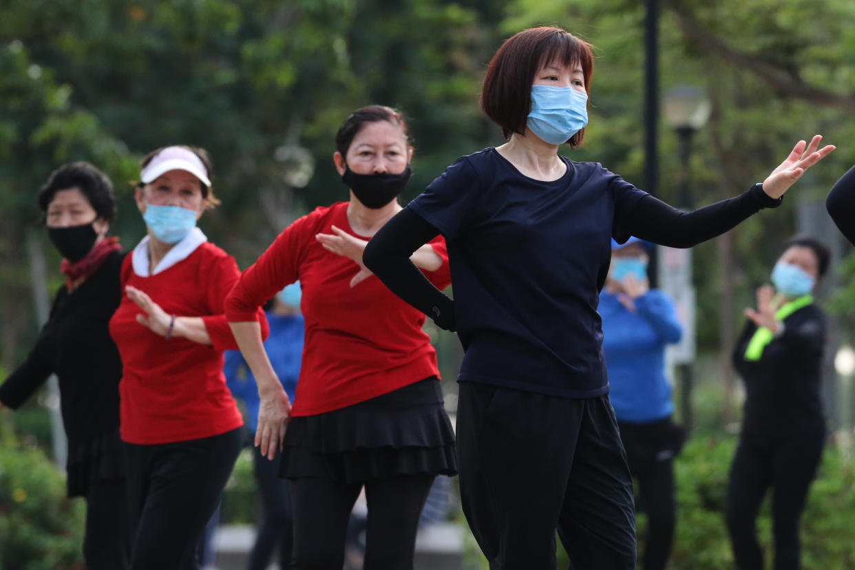 Women wearing protective mask exercise at a park on October 17, 2021 in Singapore. (Photo by Suhaimi Abdullah/NurPhoto via Getty Images)