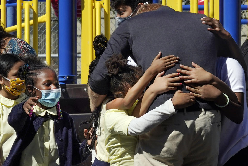 Prince Harry, the Duke of Sussex,gets a group hug from students after he and his wife Meghan, the Duchess of Sussex, visited their school, P.S. 123, the Mahalia Jackson School, in New York's Harlem neighborhood, Friday, Sept. 24, 2021. (AP Photo/Richard Drew)