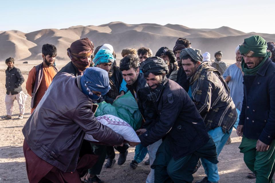 Afghan people carry the body of a relative killed in an earthquake to a burial site after an earthquake in Zenda Jan district in Herat province, western of Afghanistan, Sunday, Oct. 8, 2023.