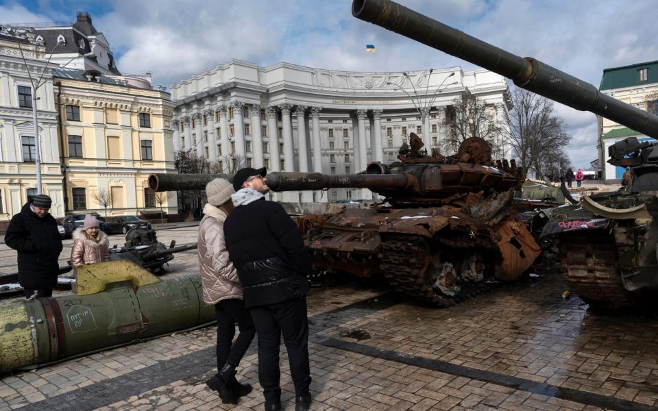 People watch destroyed Russian tanks and armoured vehicles on display near the St. Michael's Cathedral in downtown Kyiv, Ukraine, Sunday, March 12, 2023. (AP Photo/Andrew Kravchenko) - AP Photo/Andrew Kravchenko