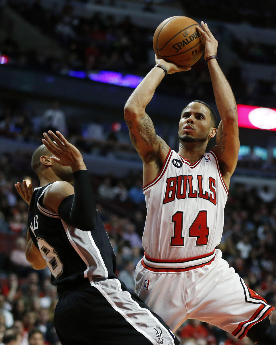 Chicago Bulls point guard D.J. Augustin (14) scores a shot over San Antonio Spurs point guard Patty Mills (8) during the second half of an NBA basketball game on Tuesday, March 11, 2014, in Chicago. The San Antonio Spurs defeated The Chicago Bulls 104-96. (AP Photo/Andrew A. Nelles)