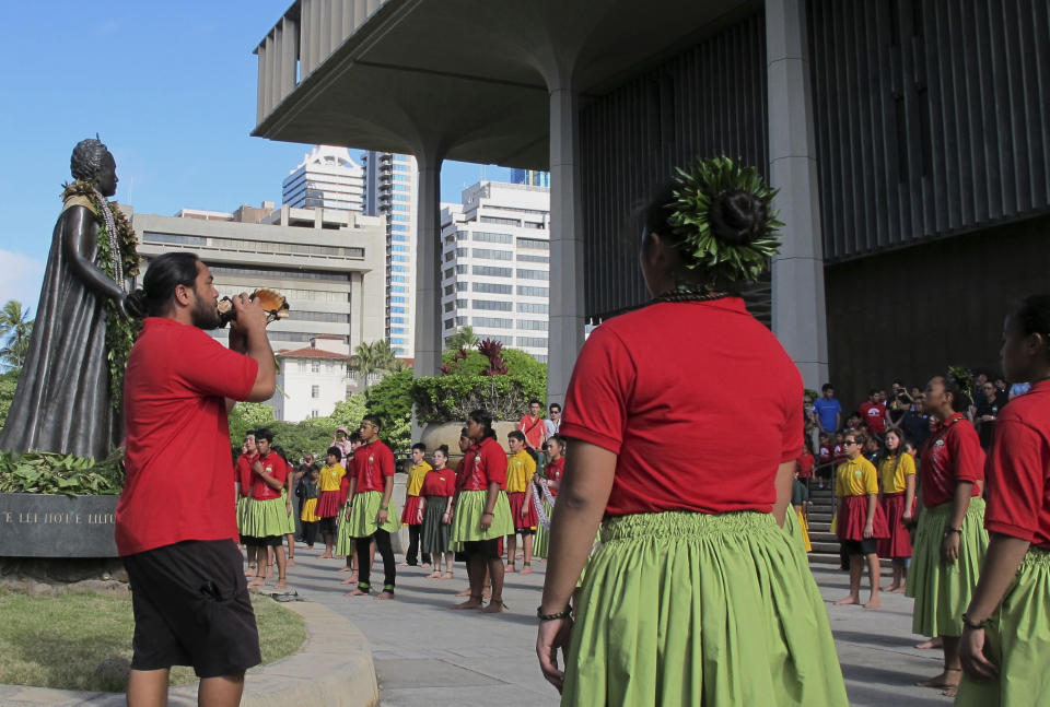 FILE - In this Jan. 18, 2017 file photo, people gather outside the Hawaii Legislature and draped lei on the statue of Queen Liliuokalani in Honolulu. A proposal on Thursday, Jan. 16, 2020, to erect a memorial to Ohio women who fought for voting rights would add the Statehouse to a small group of state capitols with monuments to actual female figures from U.S. history. (AP Photo/Cathy Bussewitz, File)