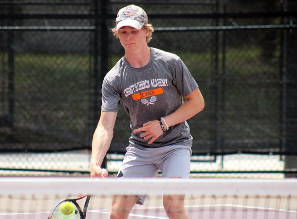 Christ's Church senior Chase Healey hits a shot at the net during a District 3-1A doubles tennis match against Hilliard on April 12.