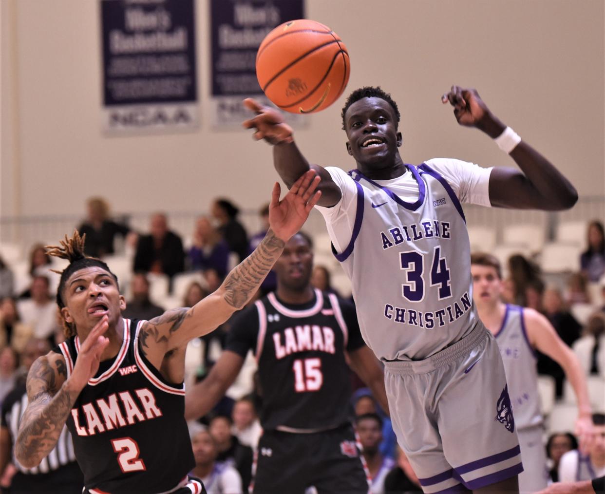 ACU's Yuot Gai, right, passes the ball to a teammate as Lamar's Avontez Ledt (2) defends in the second half. The Wildcats beat Lamar 77-42 in the Western Athletic Conference game Thursday, Feb. 24, 2022, at the Teague Center.