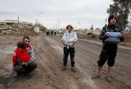 Displaced Iraqi people from the Bab al-Tob area in Mosul flee their homes after clashes to reach safe areas as Iraqi forces battle with Islamic State militants in the city of Mosul, Iraq, March 15, 2017. REUTERS/Youssef Boudlal