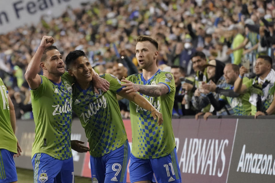 Raul Ruidiaz (9) celebrates after scoring his second goal with teammates Nico Lodeiro (left) and Albert Rusnak as the Seattle Sounders became the first MLS team to win the CONCACAF Champions League. (AP Photo/Ted S. Warren)