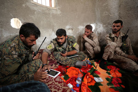 Fighters from Syrian Democratic Forces (SDF) sit together in Raqqa, Syria September 25, 2017. REUTERS/Rodi Said