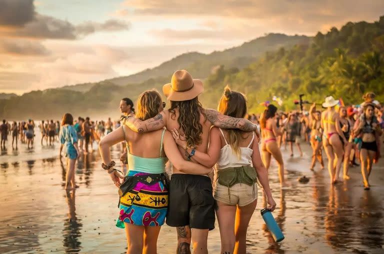 Personas caminan por la playa en un festival en Uvita, Costa Rica