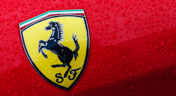 A close-up of the Ferrari logo on a red car with drops of water