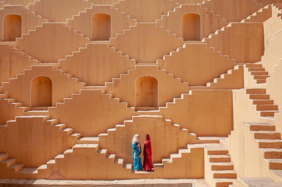 Jasmin (in red) and Manisha Singh (in blue) pose at the Baoli at Amer, a water well in the city of Japiur in India’s Rajasthan Thar desert. This image is included in “W|ALLS: Defend, Divide, and the Divine.”