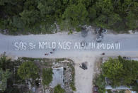 A phrase that reads in Spanish “SOS Mr. AMLO. We are being attacked. Help!!!” covers a street in the October 2 squatter settlement in Tulum, Quintana Roo state, Mexico, Thursday, Aug. 4, 2022. The message was written by the squatters, directed at Mexican President Andres Manuel Lopez Obrador after local authorities attempted to evict them from a stretch of public land that was sold by city officials to largely foreign developers. (AP Photo/Eduardo Verdugo)