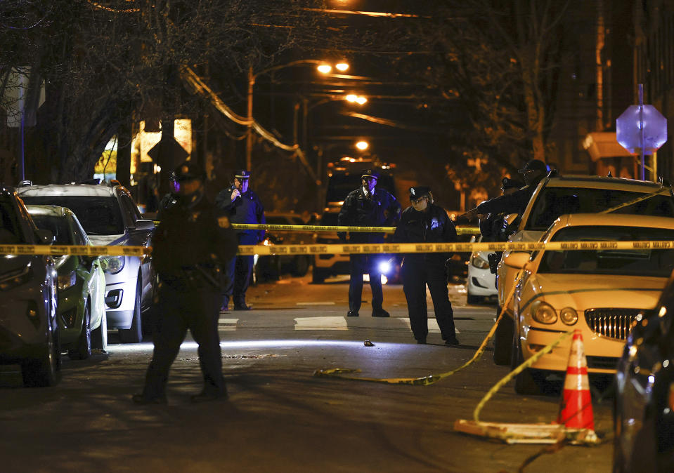 Philadelphia police officers investigate the fatal shooting of a Temple University police officer near the campus on Saturday, Feb. 18, 2023, in Philadelphia. (Yong Kim/The Philadelphia Inquirer via AP)