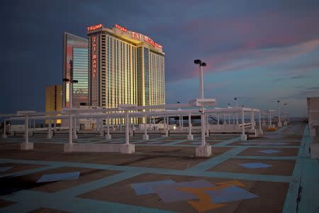 The illuminated Trump Taj Mahal Casino is seen from an empty rooftop parking lot at dusk in Atlantic City, New Jersey October 24, 2014. REUTERS/Mark Makela