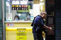 A police officer holds his gun as he is surrounded by anti-government protesters after a clash, at Mong Kok, in Hong Kong