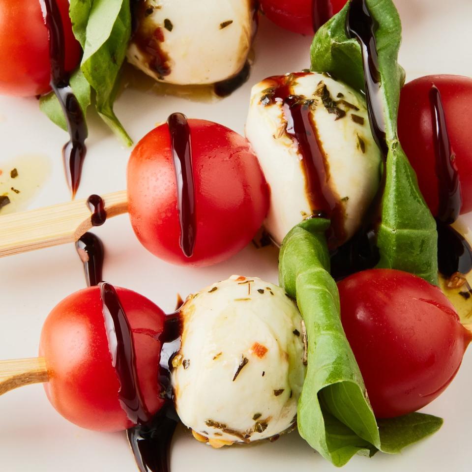 tomato, mozzarella, and basil on little skewers drizzled with balsamic glaze